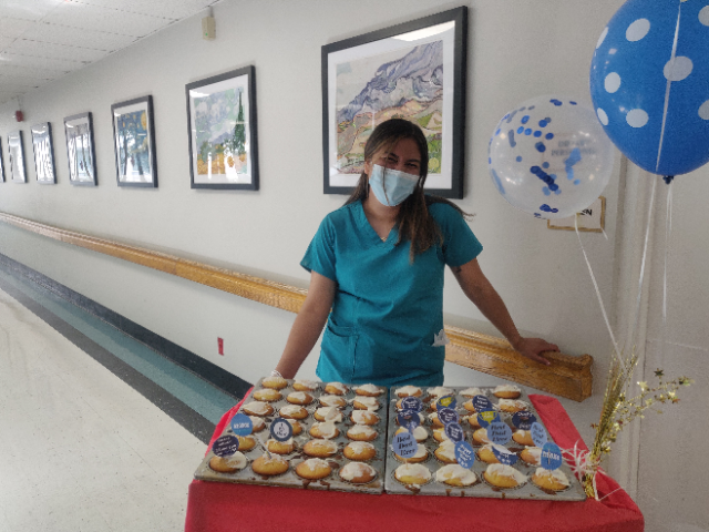Employee stands with cupcakes for Father's Day