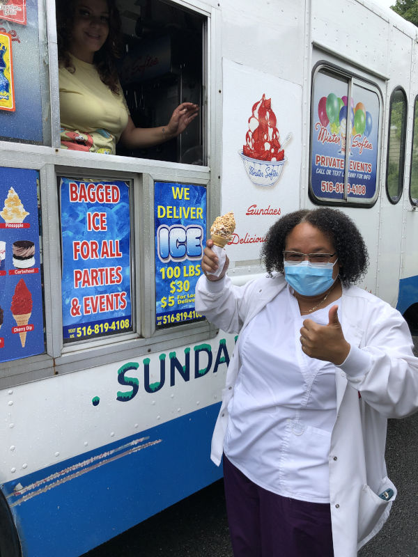 Woman employee standing in front of ice cream truck