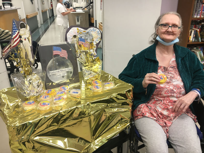 Woman holding Moon Pie next to National Moon Day table